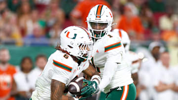 Sep 21, 2024; Tampa, Florida, USA; Miami Hurricanes quarterback Cam Ward (1) hands off to running back Damien Martinez (6) against the South Florida Bulls in the second quarter at Raymond James Stadium. Mandatory Credit: Nathan Ray Seebeck-Imagn Images