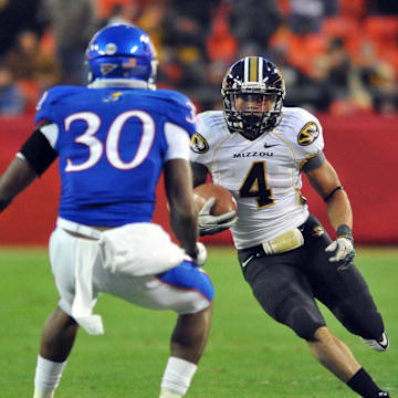 November 26, 2011; Kansas City, MO, USA; Missouri Tigers running back Kendial Lawrence (4) catches a pass as Kansas Jayhawks cornerback Anthony Davis (30) defends in the second half at Arrowhead Stadium. Missouri won 24-10.Mandatory Credit: Denny Medley-Imagn Images