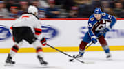 Feb 26, 2025; Denver, Colorado, USA; Colorado Avalanche center Nathan MacKinnon (29) controls the puck as New Jersey Devils defenseman Brenden Dillon (5) defends in the second period at Ball Arena. Mandatory Credit: Isaiah J. Downing-Imagn Images