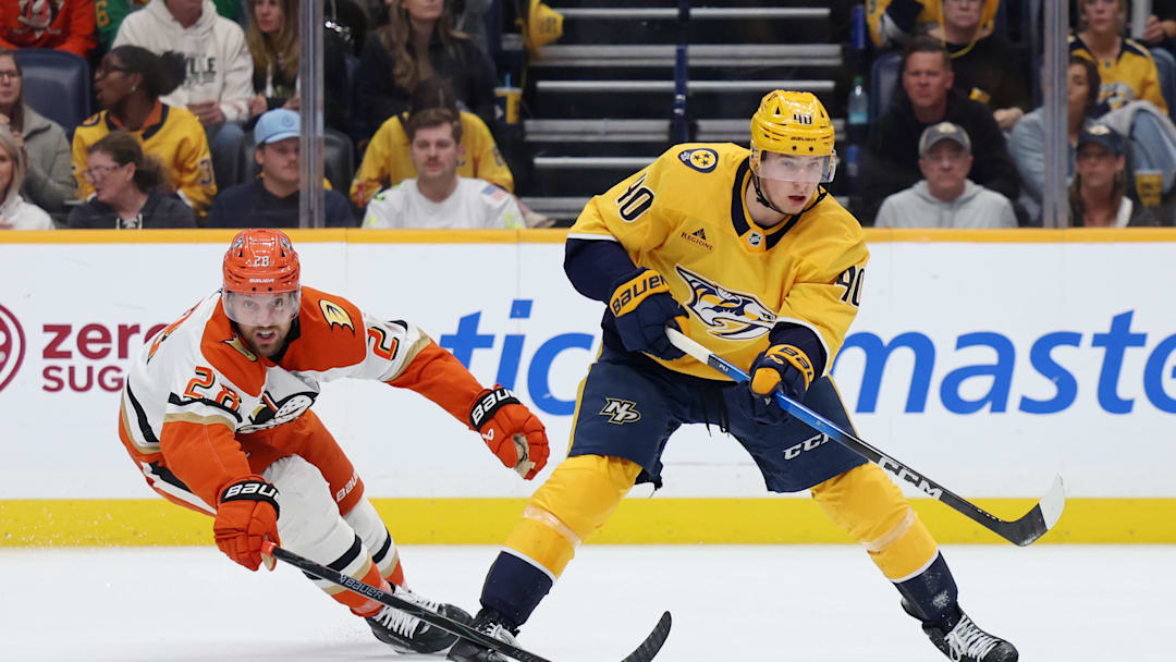 Apr 16, 2026; Nashville, Tennessee, USA; Nashville Predators center Ryan O'Reilly (90) passes the puck as Anaheim Ducks left wing Jeffrey Viel (28) approaches  during the second period of their game at Bridgestone Arena. Mandatory Credit: Alan Poizner-Imagn Images