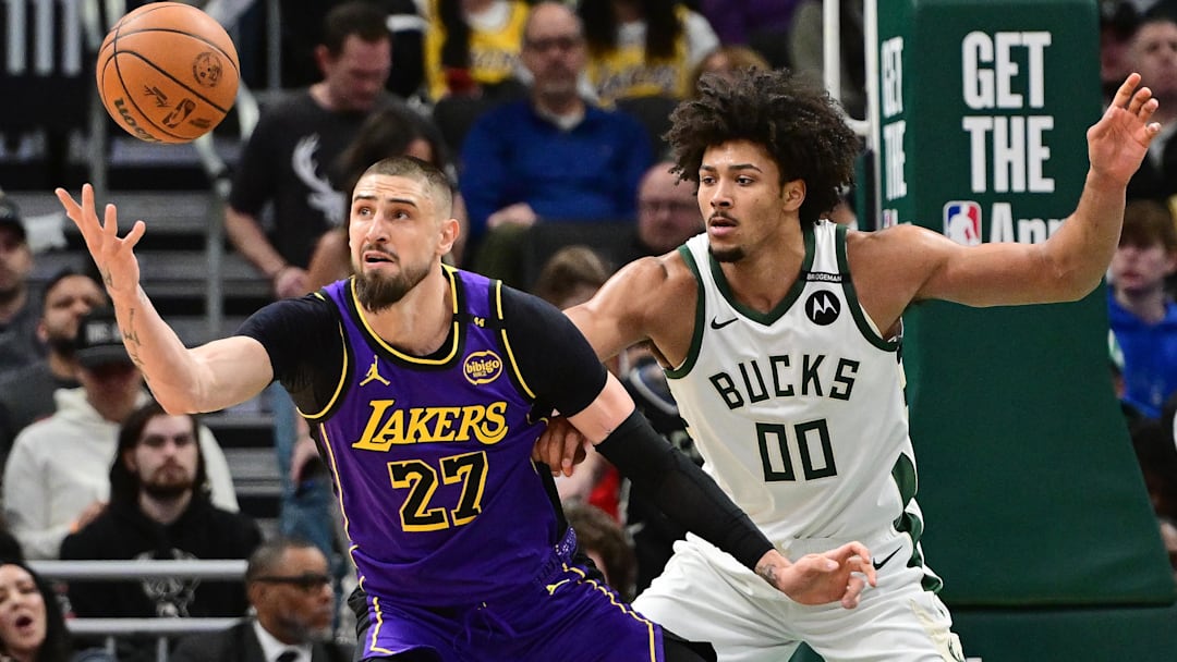 Mar 13, 2025; Milwaukee, Wisconsin, USA; Los Angeles Lakers center Alex Len (27) reaches for the ball against Milwaukee Bucks center Jericho Sims (00) in the second quarter at Fiserv Forum. Mandatory Credit: Benny Sieu-Imagn Images