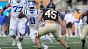Nov 30, 2024; Winston-Salem, North Carolina, USA;  Duke Blue Devils running back Jaquez Moore (9) tries to elude Wake Forest Demon Deacons defensive back Nick Andersen (45) during the second half at Allegacy Federal Credit Union Stadium. Mandatory Credit: Jim Dedmon-Imagn Images