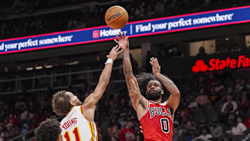 Nov 9, 2024; Atlanta, Georgia, USA; Chicago Bulls guard Coby White (0) shoots over Atlanta Hawks guard Trae Young (11) during the second half at State Farm Arena. Mandatory Credit: Dale Zanine-Imagn Images