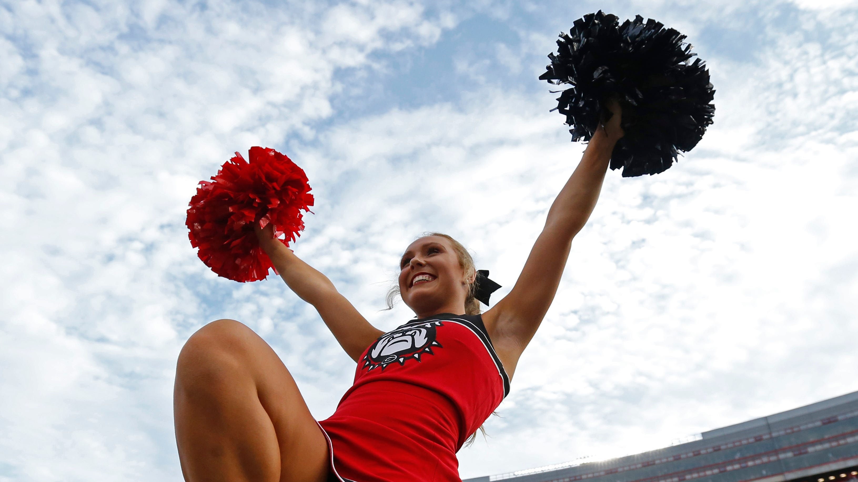 Georgia Bulldogs cheerleader performs during a college football game in the SEC.