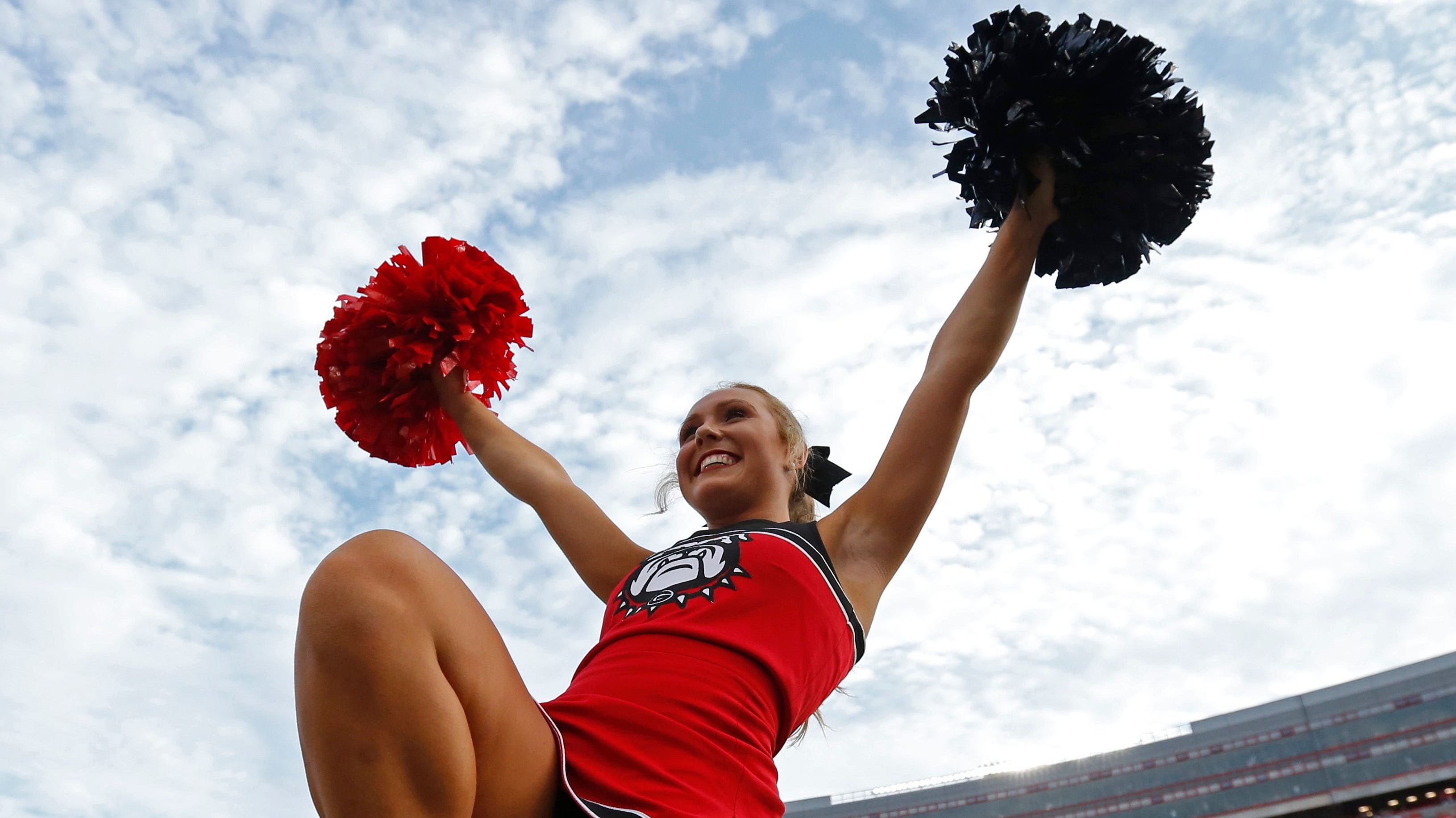 Georgia Bulldogs cheerleader performs during a college football game in the SEC.