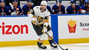 Feb 4, 2025; Elmont, New York, USA;  Vegas Golden Knights defenseman Shea Theodore (27) skates with the puck against the New York Islanders during the third period at UBS Arena. Mandatory Credit: Dennis Schneidler-Imagn Images