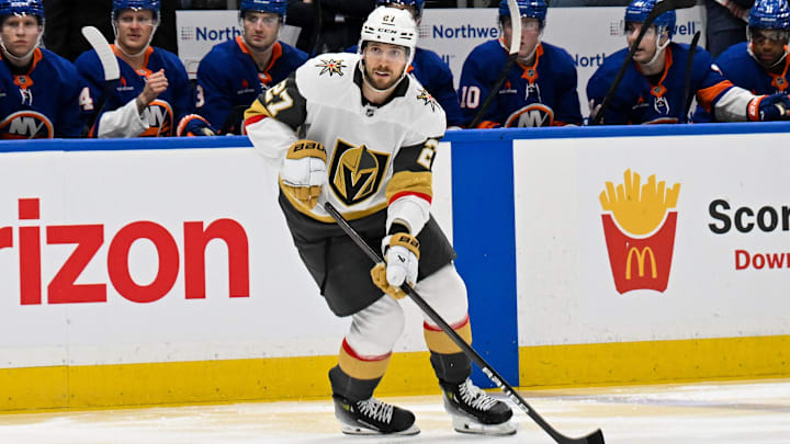 Feb 4, 2025; Elmont, New York, USA;  Vegas Golden Knights defenseman Shea Theodore (27) skates with the puck against the New York Islanders during the third period at UBS Arena. Mandatory Credit: Dennis Schneidler-Imagn Images