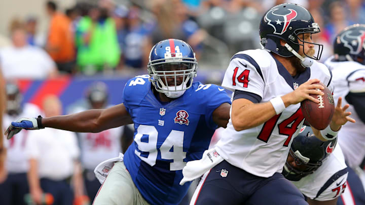 Sep 21, 2014; East Rutherford, NJ, USA; Houston Texans quarterback Ryan Fitzpatrick (14) runs from pressure by New York Giants defensive end Mathias Kiwanuka (94) during the first quarter at MetLife Stadium. Mandatory Credit: Brad Penner-Imagn Images