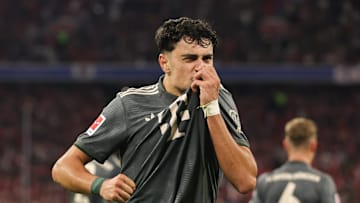 Aleksandar Pavlović kissing the badge after scoring for Bayern Munich against Bayer Leverkusen.