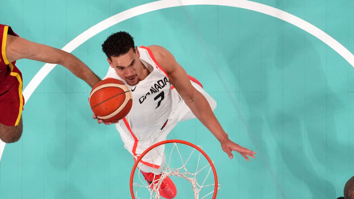 Aug 2, 2024; Villeneuve-d'Ascq, France; Canada power forward Dwight Powell (7) shoots against Spain small forward Santi Aldama (7) and guard Lorenzo Brown (2) in the first half in a men’s group A basketball game during the Paris 2024 Olympic Summer Games at Stade Pierre-Mauroy. Mandatory Credit: John David Mercer-USA TODAY Sports