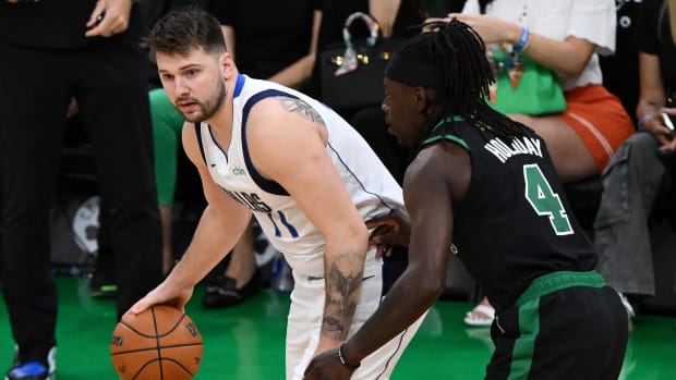 June 9, 2024;  Boston, Massachusetts, USA;  Dallas Mavericks guard Luka Doncic (77) dribbles the ball against Boston Celtics guard Jrue Holiday (4) during the first half of Game 2 of the 2024 NBA Finals at TD Garden.  Mandatory Credit: USA TODAY Sports Images