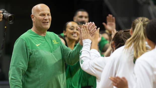 Oregon women coach Kelly Graves high-fives his team before their game against Northern Arizona at Matthew Knight Arena.