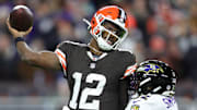 Cleveland Browns quarterback Shedeur Sanders (12) is hit by Baltimore Ravens linebacker Trenton Simpson (32) during the second half of an NFL football game at Huntington Bank Field, Nov. 16, 2025, in Cleveland, Ohio.