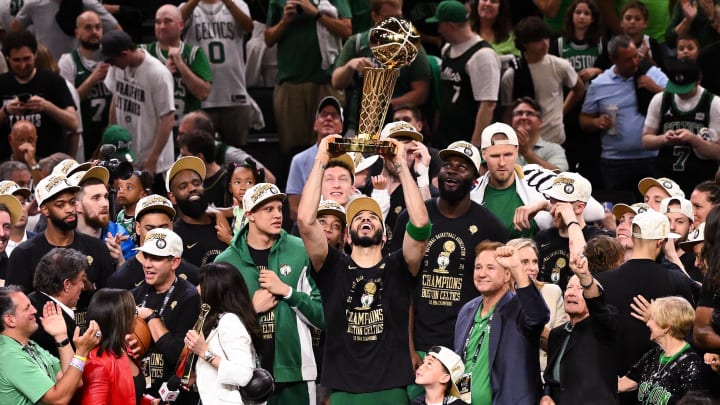 Jun 17, 2024; Boston, Massachusetts, USA; Boston Celtics forward Jayson Tatum (0) holds up the Larry O'Brien Championship Trophy after the Celtics beat the Dallas Mavericks in game five of the 2024 NBA Finals at the TD Garden. Mandatory Credit: Brian Fluharty-USA TODAY Sports