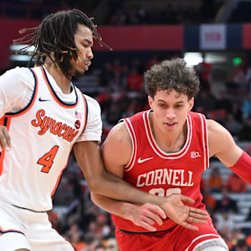 Dec 5, 2023; Syracuse, New York, USA; Cornell Big Red guard Chris Manon (30) tries to move the ball past Syracuse Orange forward Chris Bell (4) in the first half at the JMA Wireless Dome. Mandatory Credit: Mark Konezny-Imagn Images