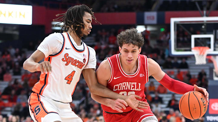 Dec 5, 2023; Syracuse, New York, USA; Cornell Big Red guard Chris Manon (30) tries to move the ball past Syracuse Orange forward Chris Bell (4) in the first half at the JMA Wireless Dome. Mandatory Credit: Mark Konezny-Imagn Images