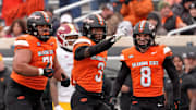 Oklahoma State's Cam Smith (3) celebrates a play with Aden Kelley (71) and Parker Robertson (8) in the first half of the college football game between the Oklahoma State Cowboys and the Iowa State Cyclones at Boone Pickens Stadium in Stillwater, Okla., Saturday Nov. 29, 2025.
