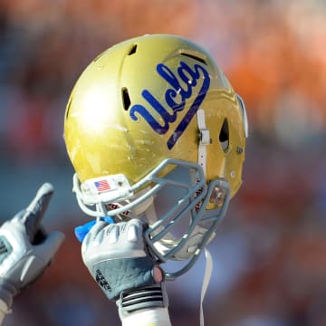 Sept 25, 2010; Austin, TX, USA; A member of the UCLA Bruins holds up his helmet to acknowledge their fans against the Texas Longhorns during the fourth quarter at Texas Memorial Stadium. UCLA beat Texas 34-12. Mandatory Credit: Brendan Maloney-USA TODAY Sports