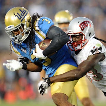 September 10, 2016; Pasadena, CA, USA;  UCLA Bruins defensive back Randall Goforth (3) carries the ball after intercepting a pass while being brought down by UNLV Rebels wide receiver Devonte Boyd (83) during the second half at Rose Bowl. Mandatory Credit: Gary A. Vasquez-Imagn Images