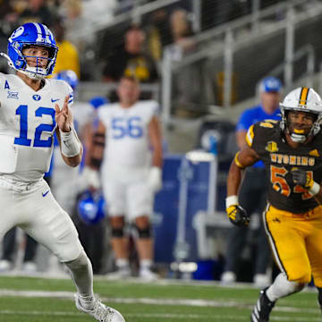 Sep 14, 2024; Laramie, Wyoming, USA; Brigham Young Cougars quarterback Jake Retzlaff (12) throws a touchdown pass against the Wyoming Cowboys during the third quarter at Jonah Field at War Memorial Stadium.