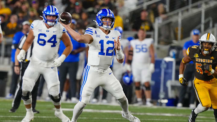 Sep 14, 2024; Laramie, Wyoming, USA; Brigham Young Cougars quarterback Jake Retzlaff (12) throws a touchdown pass against the Wyoming Cowboys during the third quarter at Jonah Field at War Memorial Stadium.