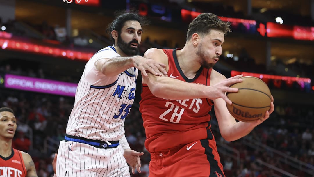 Nov 16, 2025; Houston, Texas, USA; Houston Rockets center Alperen Sengun (28) grabs a rebound away from Orlando Magic center Goga Bitadze (35) at Toyota Center. Mandatory Credit: Troy Taormina-Imagn Images