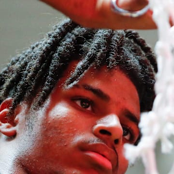 Fishers Tigers Jason Gardner (5) cuts down the net Saturday, March 15, 2025, after the IHSAA boys basketball 4A regional championship game against the Harrison Raiders at Frankfort High School in Frankfort, Ind. Fishers won 89-39.