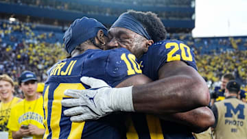 Michigan quarterback Alex Orji (10), left, hugs running back Kalel Mullings (20) after 27-24 win over USC at Michigan Stadium in Ann Arbor on Saturday, Sept. 21, 2024.