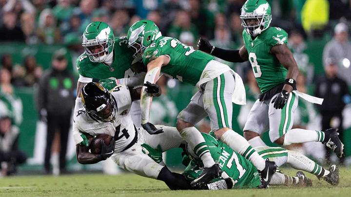 Nov 3, 2024; Philadelphia, Pennsylvania, USA; Jacksonville Jaguars running back Tank Bigsby (4) is tackled by Philadelphia Eagles linebacker Nakobe Dean (17) and cornerback Isaiah Rodgers (34) during the fourth quarter at Lincoln Financial Field. Mandatory Credit: Bill Streicher-Imagn Images