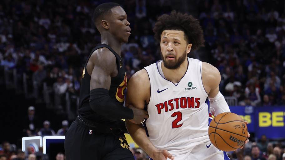 Pistons guard Cade Cunningham dribbles defended by Cavaliers guard Dennis Schroder.