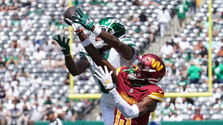 Aug 10, 2024; East Rutherford, New Jersey, USA; Washington Commanders cornerback Emmanuel Forbes (13) breaks up a pass to New York Jets wide receiver Mike Williams (18) during the first quarter at MetLife Stadium. Mandatory Credit: Lucas Boland-Imagn Images