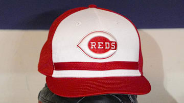 Apr 4, 2025; Milwaukee, Wisconsin, USA; Cincinnati Reds hat and glove rest on the bench in the dugout before a game against the Milwaukee Brewers at American Family Field. Mandatory Credit: Michael McLoone-Imagn Images