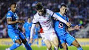 Armando González de Chivas defiende el esférico de Erik Lira y el colombiano Willer Ditta, ambos de Cruz Azul