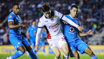 Armando González de Chivas defiende el esférico de Erik Lira y el colombiano Willer Ditta, ambos de Cruz Azul