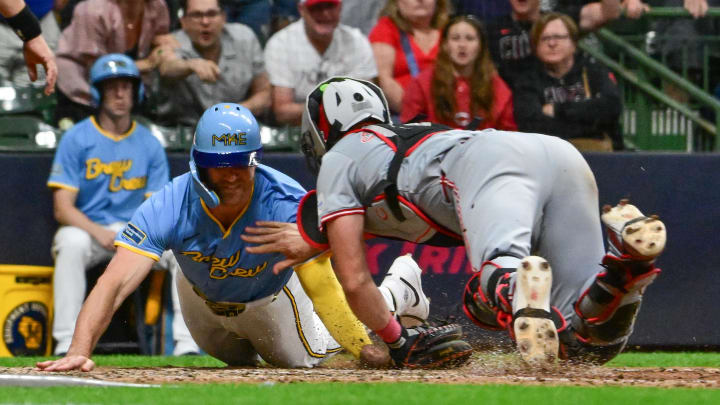 Jun 14, 2024; Milwaukee, Wisconsin, USA; Cincinnati Reds catcher Tyler Stephenson (37) tags out Milwaukee Brewers  first baseman Jake Bauers (9) trying to score in the ninth inning at American Family Field. Mandatory Credit: Benny Sieu-USA TODAY Sports