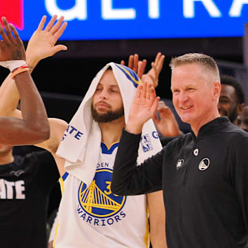 Golden State Warriors forward Jonathan Kuminga (00) high fives guard Stephen Curry (30) and head coach Steve Kerr as a time out is called against the Atlanta Hawks during the fourth quarter at Chase Center. 