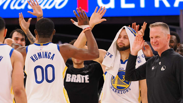 Golden State Warriors forward Jonathan Kuminga (00) high fives guard Stephen Curry (30) and head coach Steve Kerr as a time out is called against the Atlanta Hawks during the fourth quarter at Chase Center. 