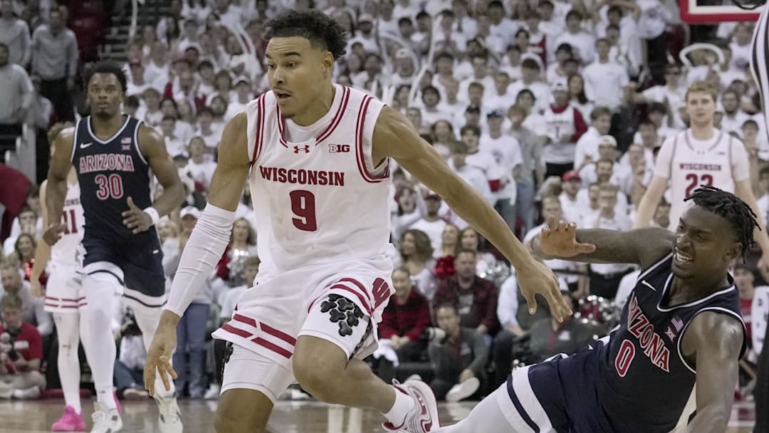 Nov 15, 2024; Madison, Wisconsin, USA;Arizona guard Jaden Bradley (0) fouls Wisconsin guard John Tonje (9) during the second half of their game Friday, November 15, 2024 at the Kohl Center in Madison, Wisconsin. Mandatory Credit: Mark Hoffman/USA TODAY Network via Imagn Images Nov 15, 2024; Madison, Wisconsin, USA;Arizona guard Jaden Bradley (0) fouls Wisconsin guard John Tonje (9) during the second half of their game Friday, November 15, 2024 at the Kohl Center in Madison, Wisconsin. Mandatory Credit: Mark Hoffman/USA TODAY Network via Imagn Images