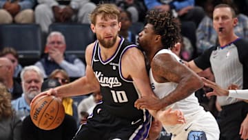Dec 31, 2023; Memphis, Tennessee, USA; Sacramento Kings forward Domantas Sabonis (10) dribbles as Memphis Grizzlies guard Marcus Smart (36) defends during the second half at FedExForum. Mandatory Credit: Petre Thomas-Imagn Images