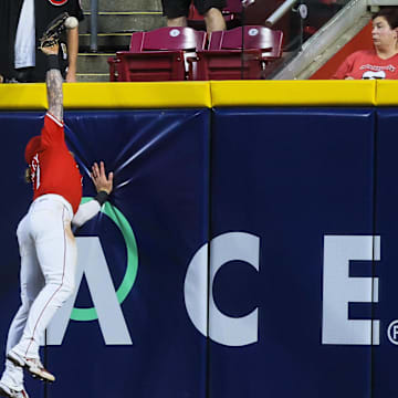 Jun 17, 2025; Cincinnati, Ohio, USA; Cincinnati Reds outfielder Jake Fraley (27) attempts to catch a home run hit by Minnesota Twins outfielder Harrison Bader (not pictured) in the sixth inning at Great American Ball Park. Mandatory Credit: Katie Stratman-Imagn Images