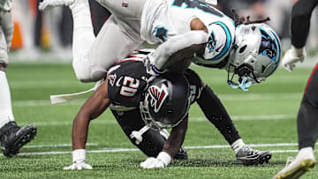Jan 5, 2025; Atlanta, Georgia, USA; Carolina Panthers running back Mike Boone (34) is upended by Atlanta Falcons cornerback Dee Alford (20) during the second half at Mercedes-Benz Stadium. Mandatory Credit: Dale Zanine-Imagn Images