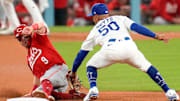 Cincinnati Reds second baseman Matt McLain (9) beats a tag from Los Angeles Dodgers shortstop Mookie Betts (50) at second base in the eighth inning of the MLB National League Wild Card Game 1 between the Los Angeles Dodgers and the Cincinnati Reds at Dodger Stadium in Los Angeles on Tuesday, Sept. 30, 2025. The Dodgers won game 1 of the series, 10-5.