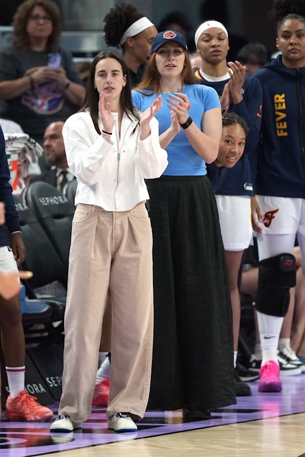 Indiana Fever guard Caitlin Clark and forward Chloe Bibby (center applaud from the bench
