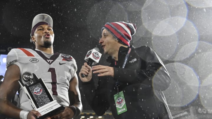 Dec 27, 2023; Annapolis, MD, USA;  Virginia Tech Hokies quarterback Kyron Drones (1) reacts during a post game interview after being award the game MVP  after the game against the Tulane Green Wave at Navy-Marine Corps Memorial Stadium. Mandatory Credit: Tommy Gilligan-USA TODAY Sports