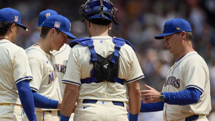 Seattle Mariners starting pitcher Bryan Woo (22) hands the ball to Seattle Mariners manager Scott Servais (9) while changing pitchers during the sixth inning  at T-Mobile Park on July 21.