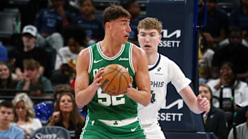Oct 8, 2025; Memphis, Tennessee, USA; Boston Celtics center Luka Garza (52) handles the ball as Memphis Grizzlies center Lawson Lovering (34) defends during the third quarter at FedExForum. Mandatory Credit: Petre Thomas-Imagn Images