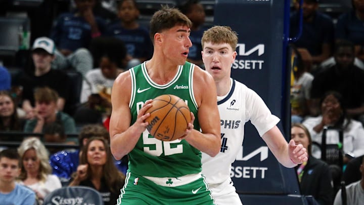 Oct 8, 2025; Memphis, Tennessee, USA; Boston Celtics center Luka Garza (52) handles the ball as Memphis Grizzlies center Lawson Lovering (34) defends during the third quarter at FedExForum. Mandatory Credit: Petre Thomas-Imagn Images