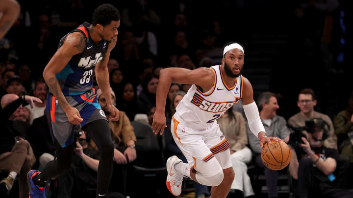 Jan 31, 2024; Brooklyn, New York, USA; Phoenix Suns forward Josh Okogie (2) brings the ball up court against Brooklyn Nets center Nic Claxton (33) during the second quarter at Barclays Center. Mandatory Credit: Brad Penner-USA TODAY Sports