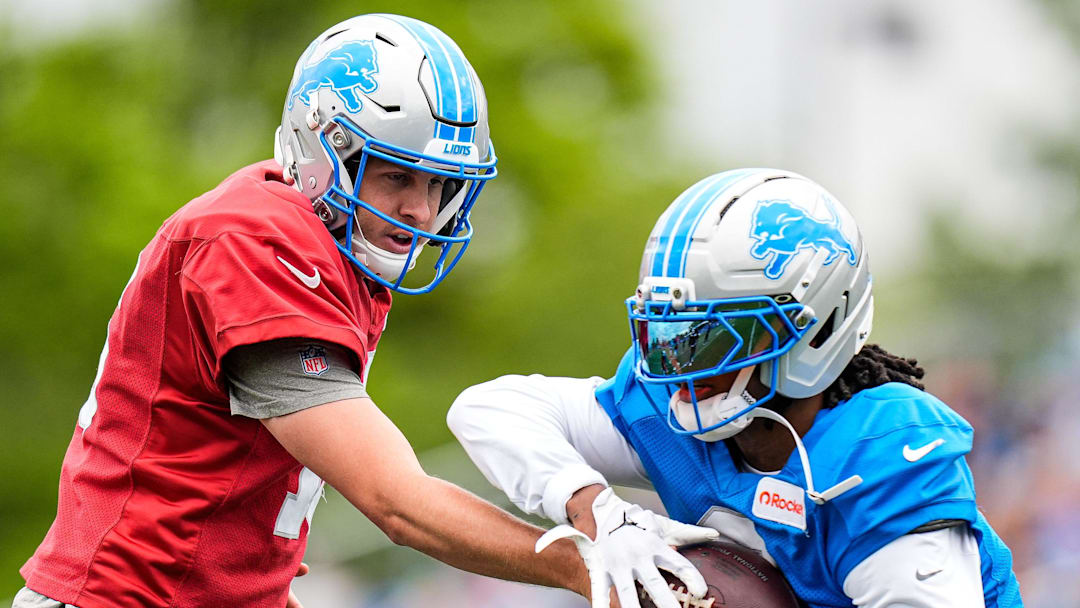 Detroit Lions quarterback Jared Goff (16) practices with running back Jahmyr Gibbs (0).