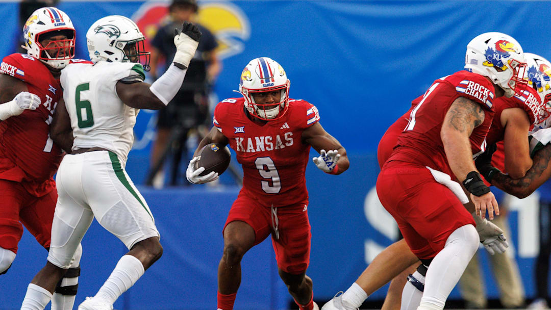 Aug 29, 2025; Lawrence, Kansas, USA; Kansas Jayhawks running back Daniel Hishaw Jr. (9) runs the ball during the first half against the Wagner Seahawks  at David Booth Kansas Memorial Stadium. Mandatory Credit: William Purnell-Imagn Images